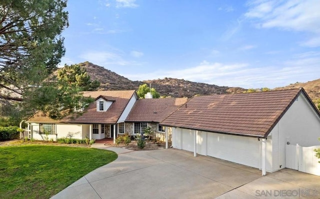 view of front facade with a mountain view, a garage, and a front lawn