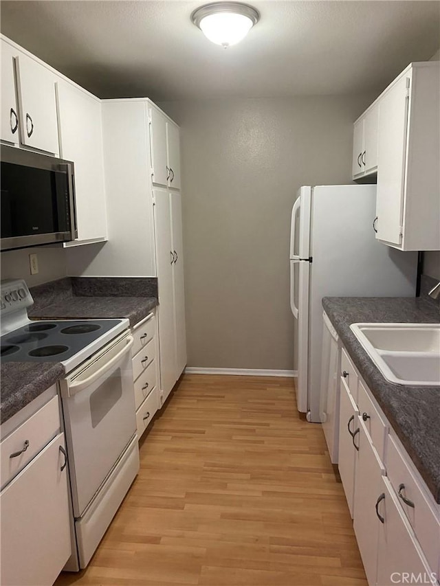 kitchen featuring white cabinetry, sink, light hardwood / wood-style floors, and white appliances