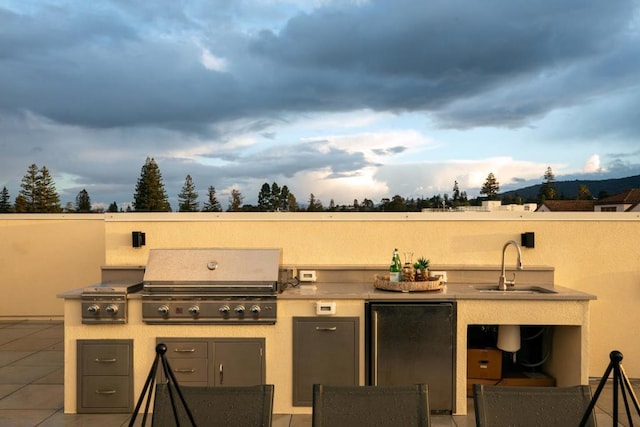 view of patio / terrace featuring an outdoor kitchen, sink, and a grill