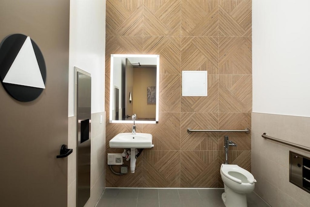 bathroom featuring toilet, tile walls, tile patterned floors, and sink