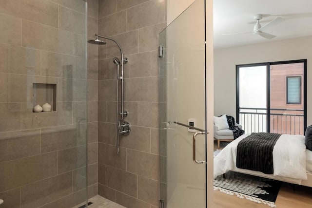 bathroom featuring ceiling fan, a shower with shower door, and wood-type flooring