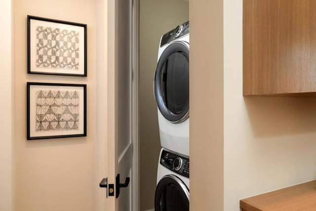 laundry area featuring stacked washer / drying machine