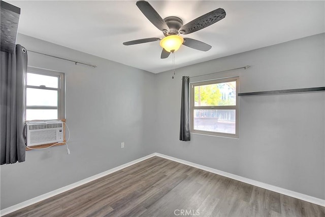 spare room featuring wood-type flooring, cooling unit, and ceiling fan