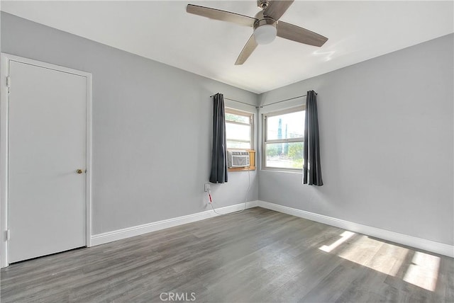 empty room featuring hardwood / wood-style floors, ceiling fan, and cooling unit