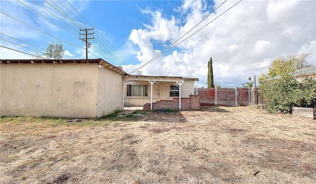 back of property featuring covered porch