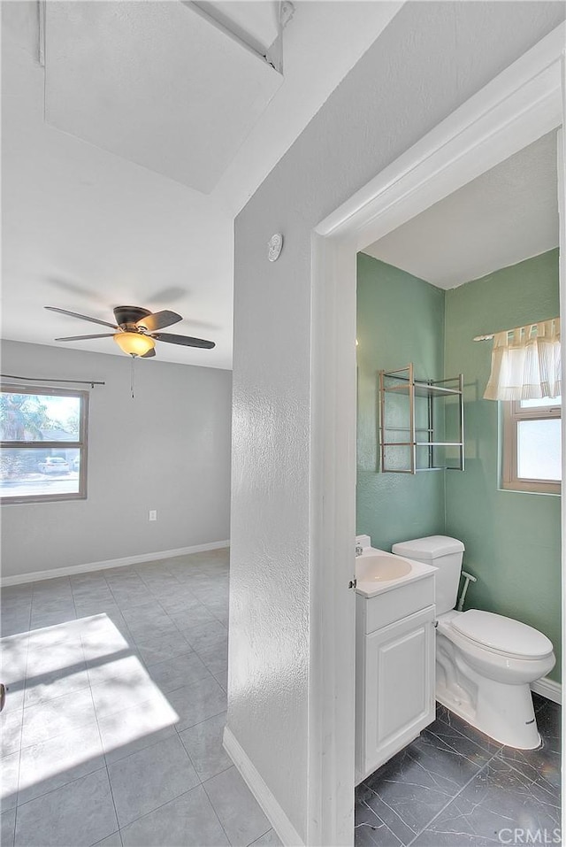 bathroom with vanity, toilet, plenty of natural light, and ceiling fan