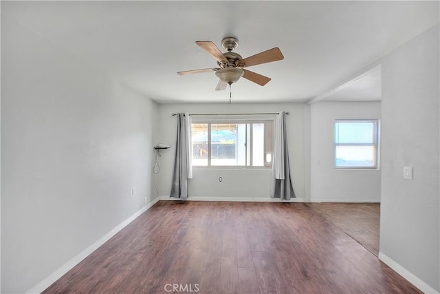 empty room with ceiling fan and dark wood-type flooring