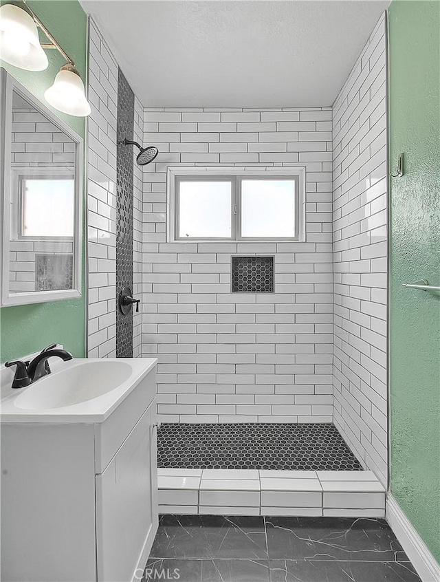 bathroom with vanity and tiled shower