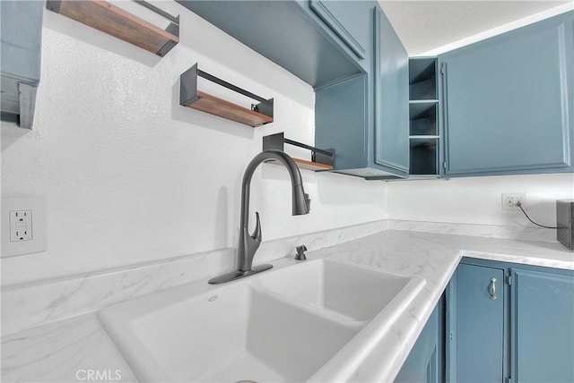 kitchen with blue cabinetry and sink