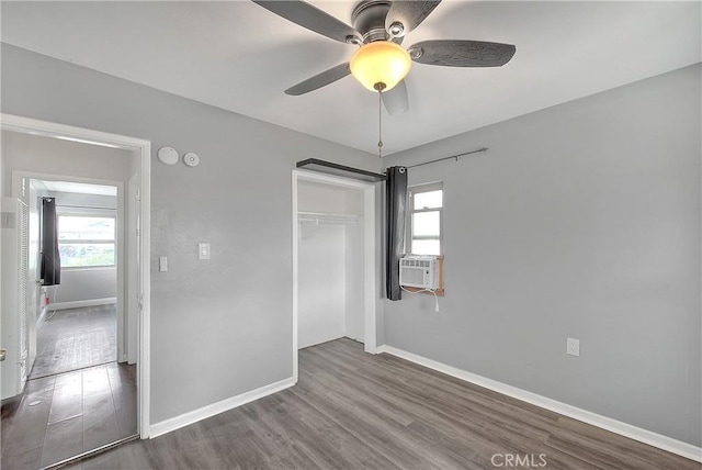 unfurnished bedroom featuring hardwood / wood-style flooring, ceiling fan, a closet, and multiple windows