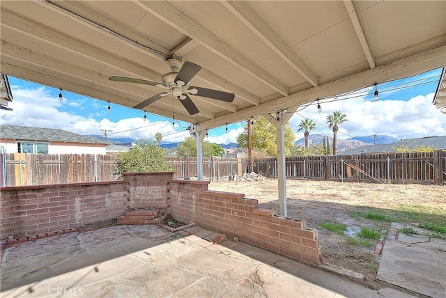 view of patio featuring ceiling fan and a mountain view