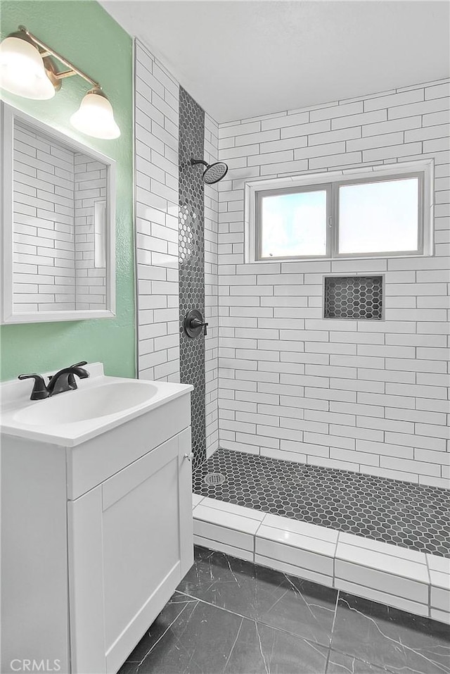 bathroom featuring vanity and tiled shower