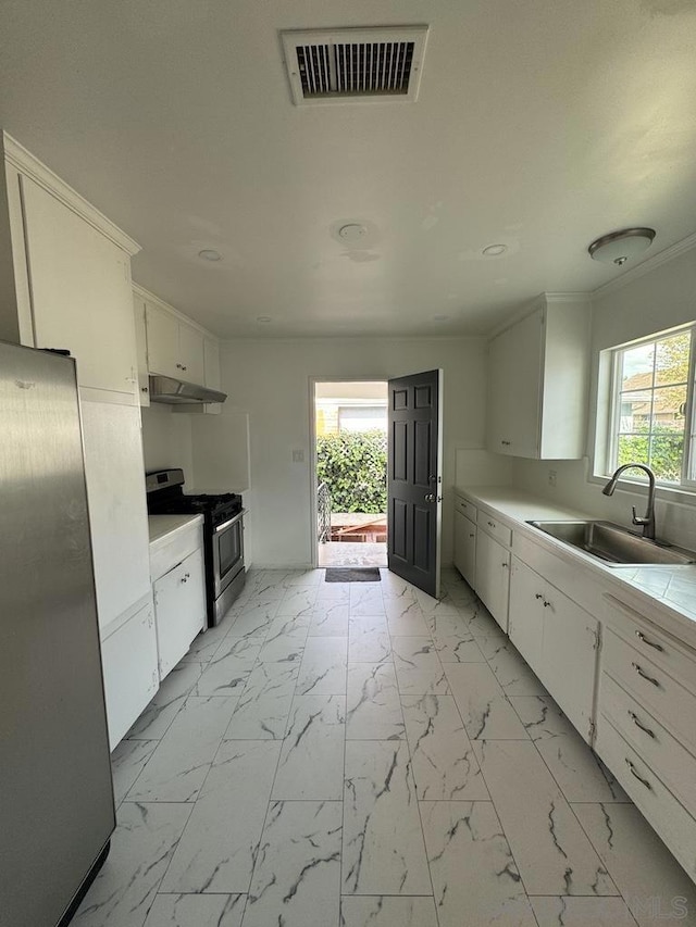 kitchen featuring stainless steel appliances, white cabinetry, and sink