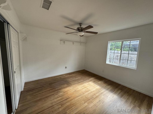 unfurnished bedroom featuring hardwood / wood-style floors, a closet, and ceiling fan