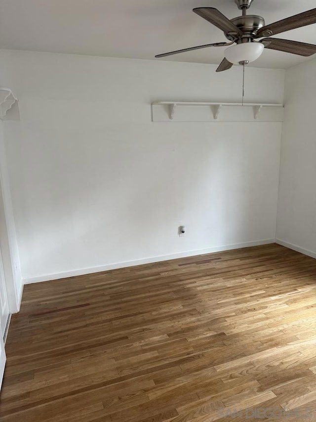 empty room with dark hardwood / wood-style floors and ceiling fan