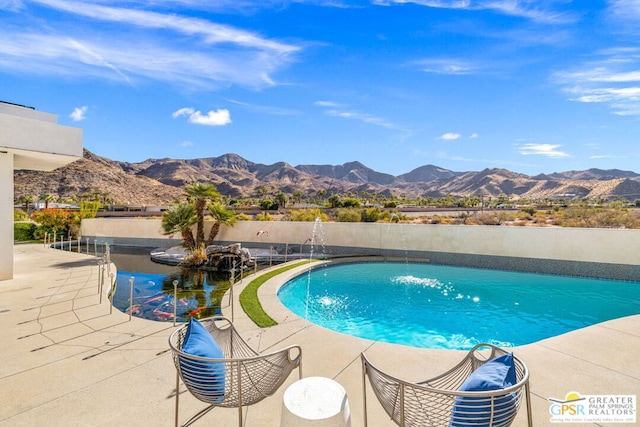 view of pool featuring pool water feature, a mountain view, and a patio