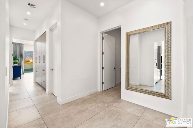 hall with light tile patterned floors