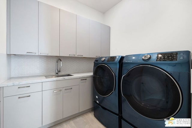 washroom with sink, light hardwood / wood-style flooring, cabinets, and independent washer and dryer