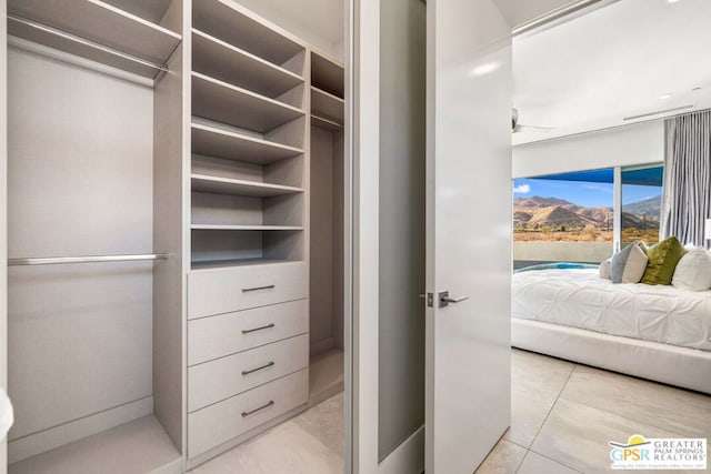 spacious closet with ceiling fan and light tile patterned floors