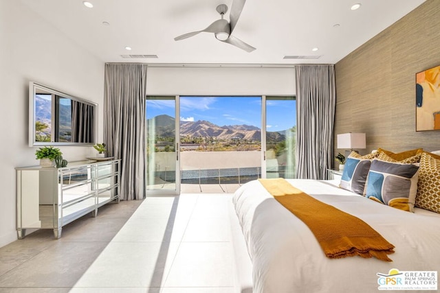 bedroom with access to outside, multiple windows, ceiling fan, and a mountain view