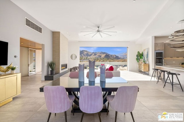 dining room with a large fireplace and ceiling fan