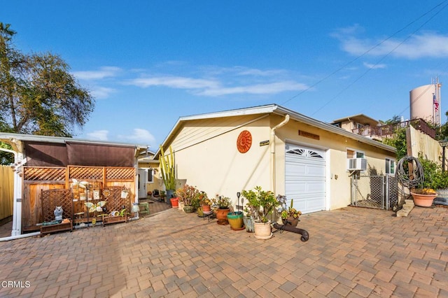 view of side of property featuring a garage and cooling unit