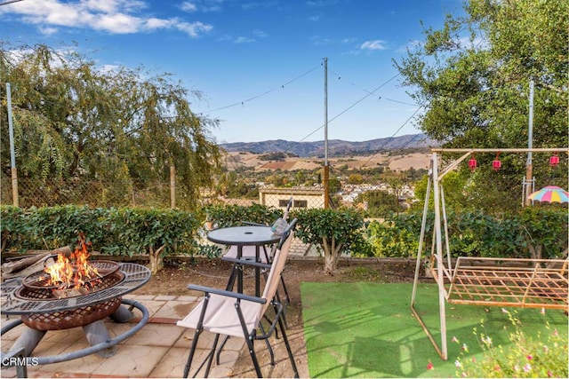 view of patio / terrace featuring a fire pit and a mountain view