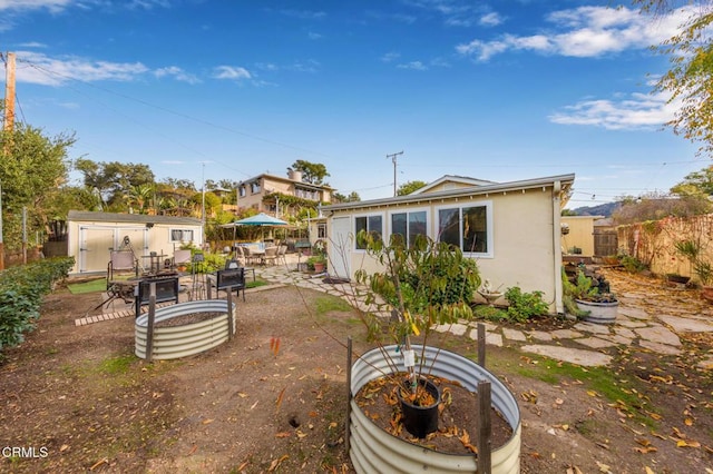 back of house featuring a patio and a storage unit