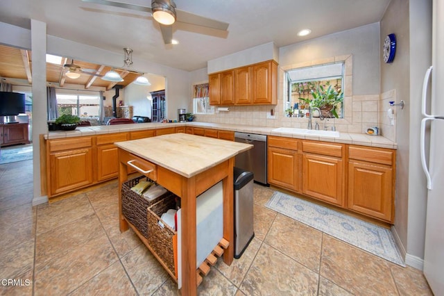 kitchen featuring backsplash, dishwasher, beamed ceiling, and sink