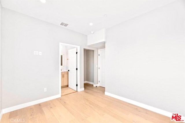 interior space with ensuite bathroom and light hardwood / wood-style flooring