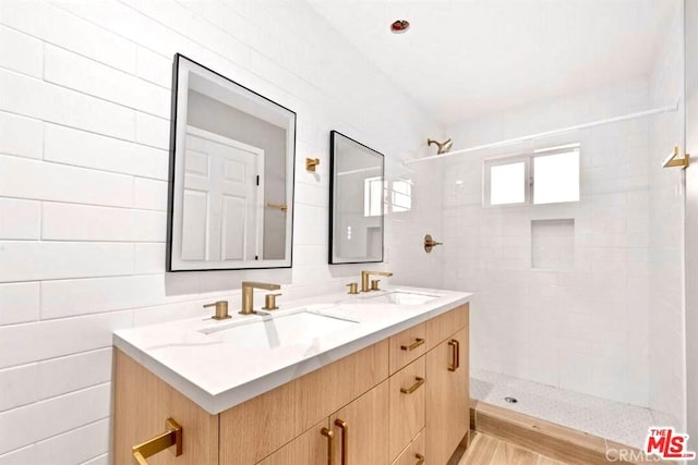 bathroom featuring tiled shower, vanity, tile walls, and hardwood / wood-style flooring