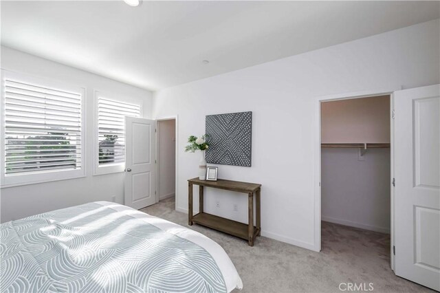 carpeted bedroom featuring a closet and a walk in closet