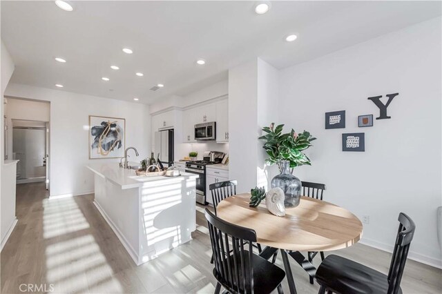 dining area featuring light hardwood / wood-style floors and sink