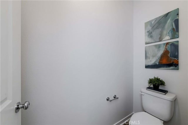 bathroom featuring toilet and baseboards