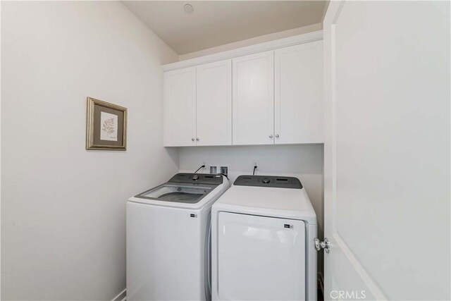 laundry area featuring washer and dryer and cabinets