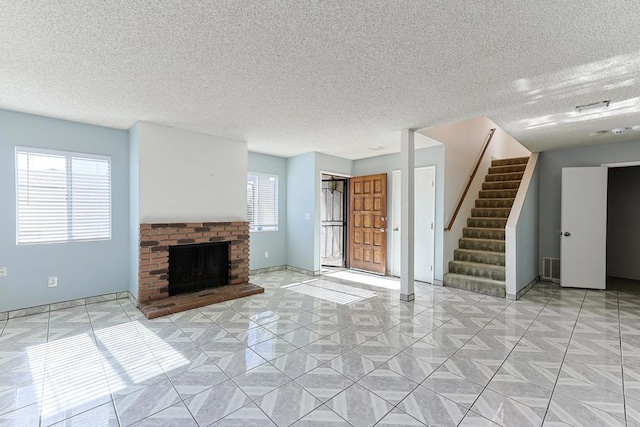 unfurnished living room with a fireplace and a textured ceiling