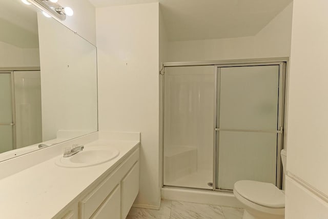 bathroom featuring vanity, toilet, and a shower with door