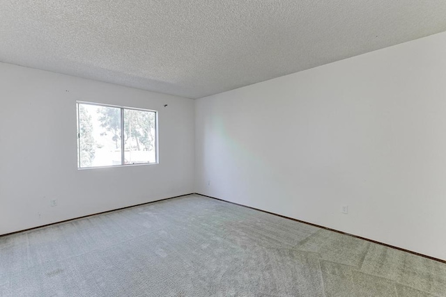 empty room with light carpet and a textured ceiling