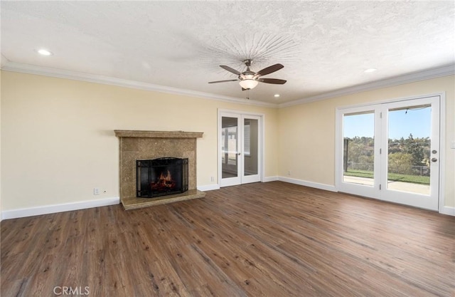 unfurnished living room with ceiling fan, a fireplace, dark hardwood / wood-style floors, and ornamental molding