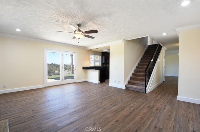 unfurnished living room featuring a textured ceiling, dark hardwood / wood-style flooring, and ornamental molding