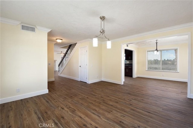 interior space featuring dark hardwood / wood-style flooring, an inviting chandelier, a textured ceiling, and ornamental molding