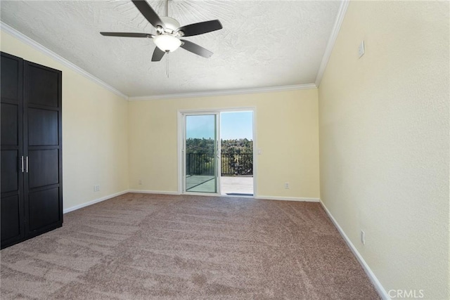 carpeted empty room with ceiling fan, a textured ceiling, and ornamental molding