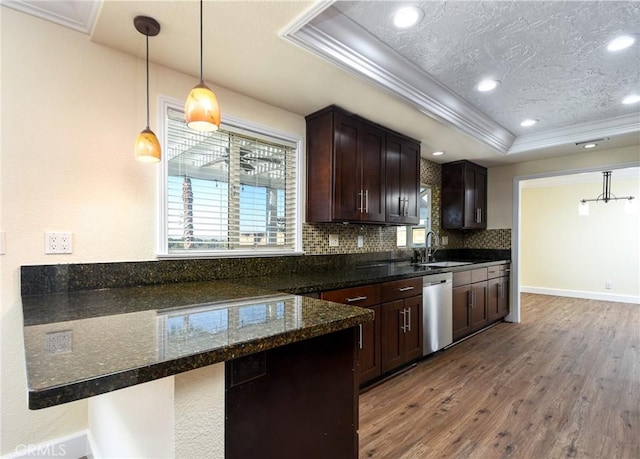 kitchen featuring dark hardwood / wood-style floors, a raised ceiling, ornamental molding, and decorative light fixtures