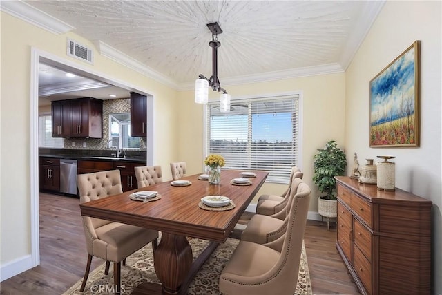 dining area with sink, dark hardwood / wood-style flooring, and ornamental molding