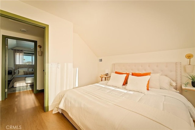 bedroom with lofted ceiling and hardwood / wood-style flooring