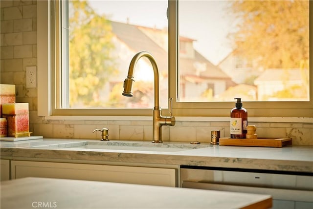 details with dishwasher, sink, and light stone countertops