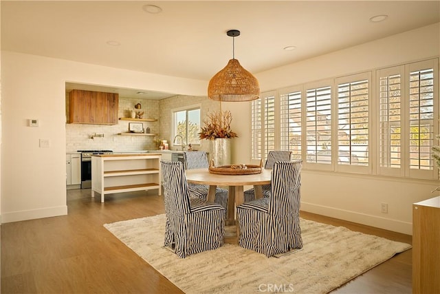 dining area with sink and light wood-type flooring