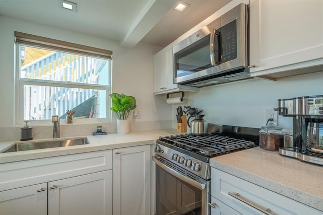 kitchen with sink, white cabinetry, and stainless steel appliances