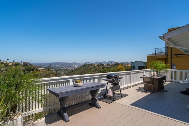 wooden deck with a mountain view and a grill