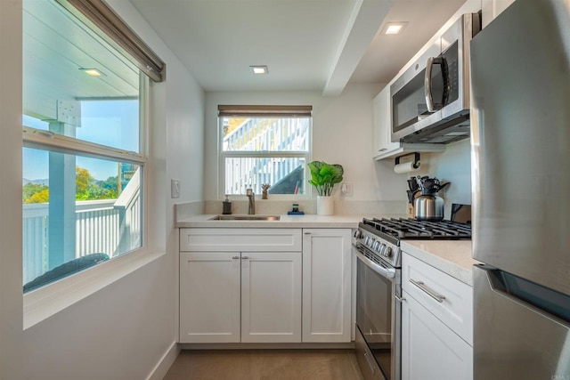 kitchen with white cabinets, stainless steel appliances, and sink